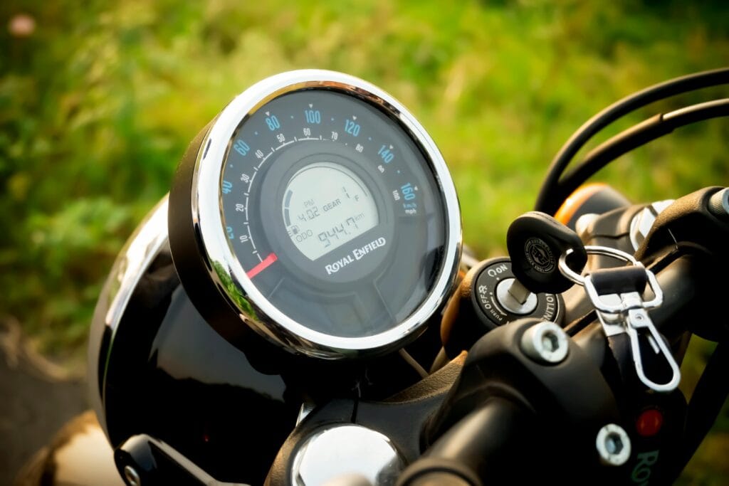 Detailed view of a Royal Enfield motorcycle speedometer with keys in the ignition.